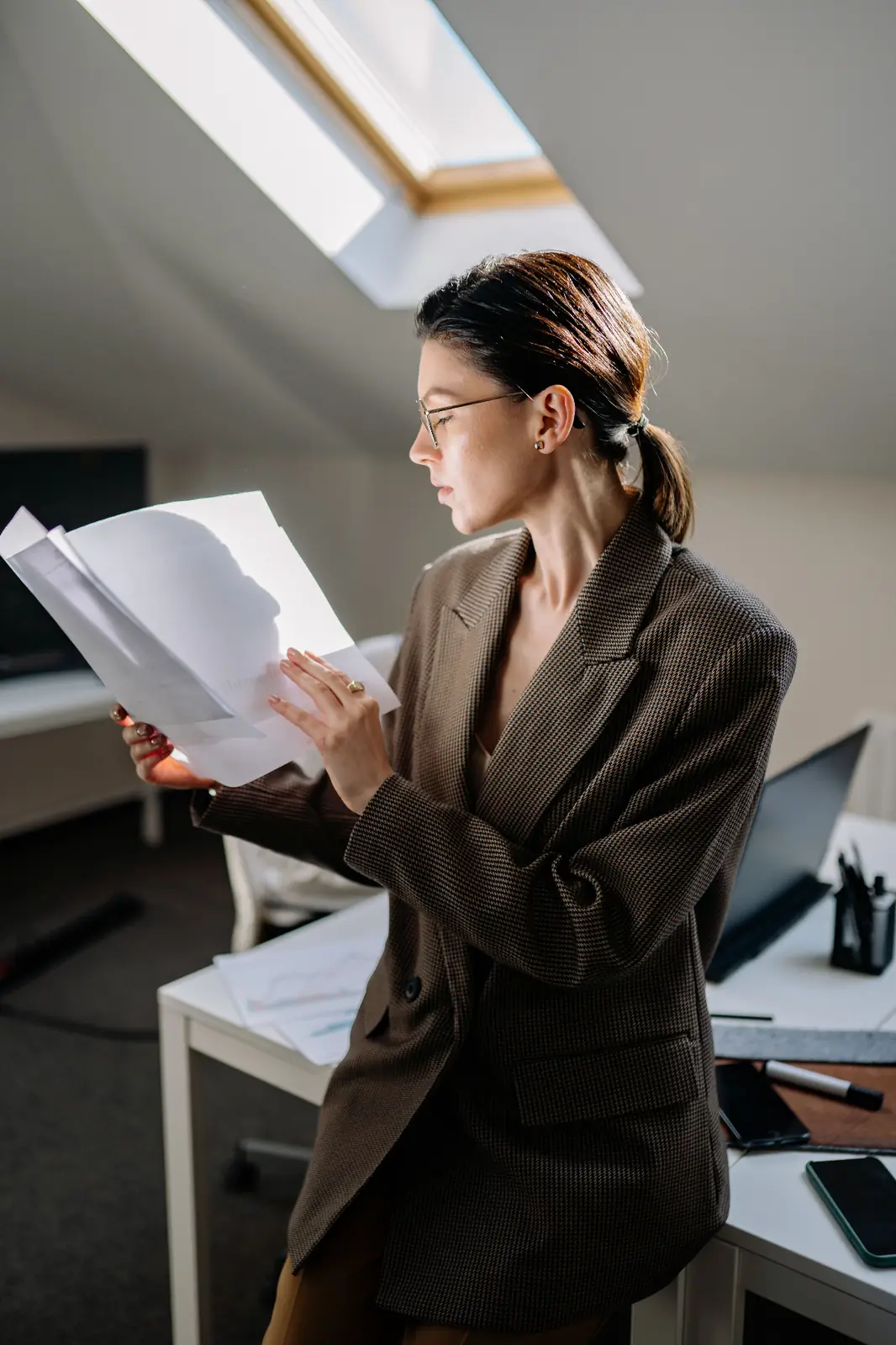 A founder working quietly at a minimal desk in a calm architectural office